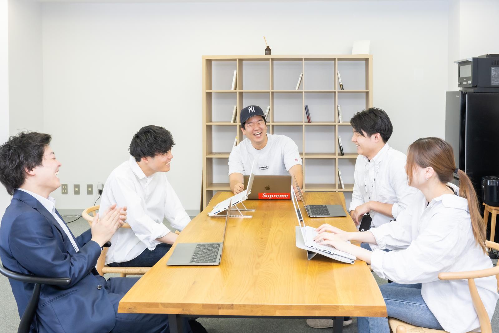 チームが会議中に笑い合う様子